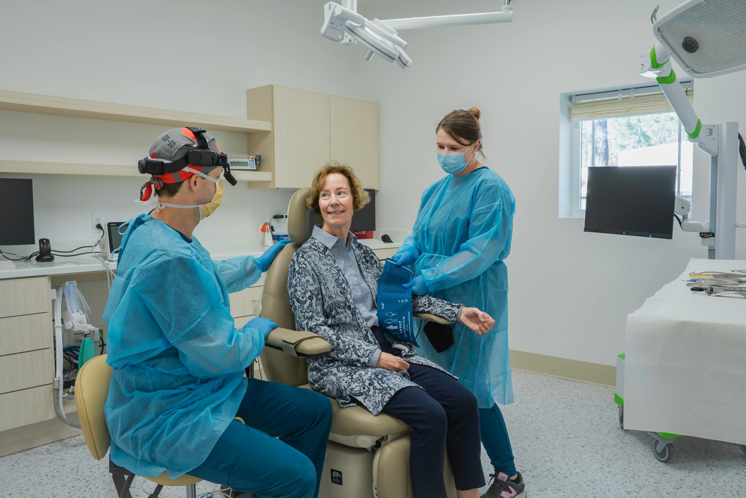Patient receiving dental checkup in modern clinic with two professionals in Brunswick, Georgia.